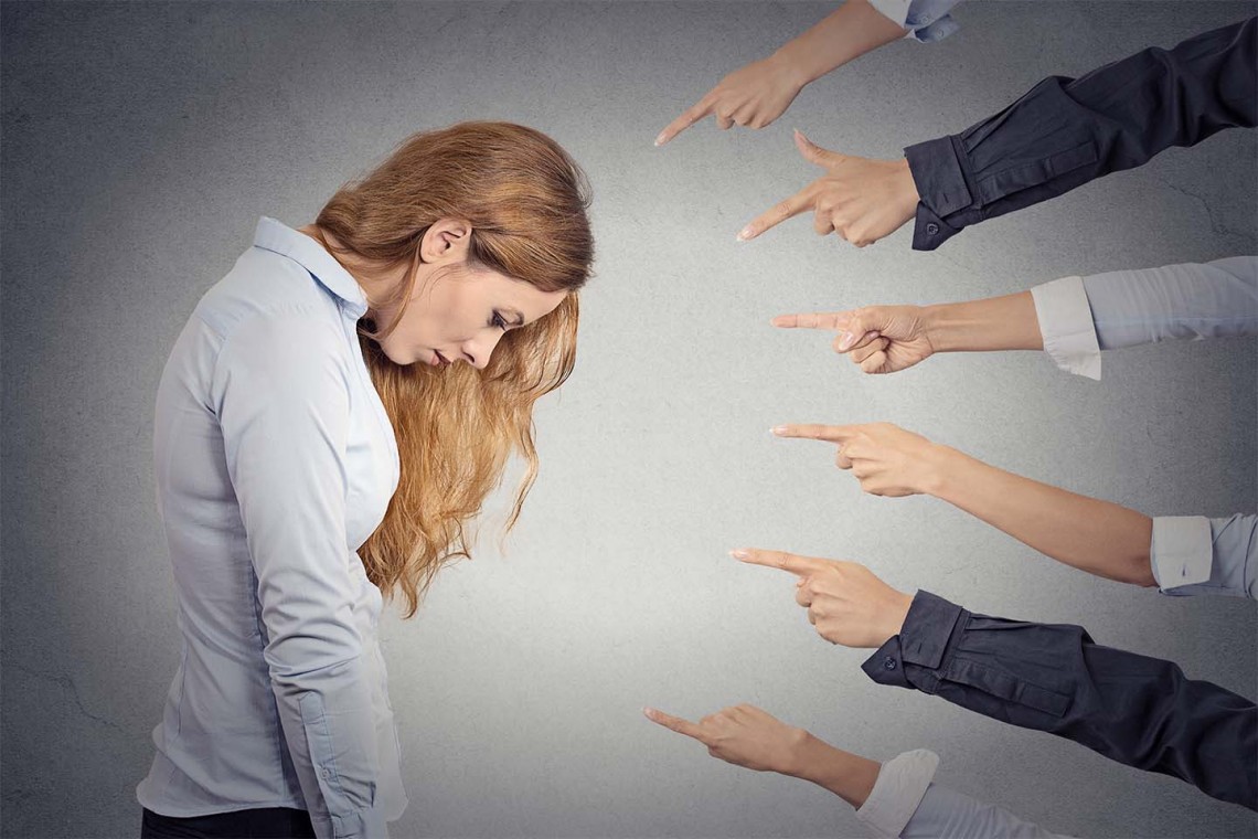 Concept of accusation of guilty businesswoman. Side profile portrait sad upset woman looking down many fingers pointing at her isolated grey office background. Human face expression emotion feeling